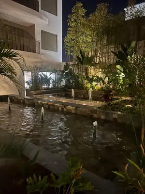 a pond in the middle of a garden at night at L'oasis - by Mi-haven in Casablanca