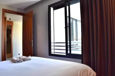 a bedroom with a large bed and a large window at Le Palmier - By Mi-Haven in Casablanca