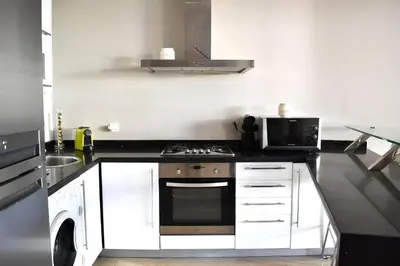 a kitchen with a stove and a microwave at Le Sacré-Coeur - by Mi-Haven in Casablanca