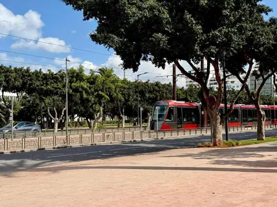 a red train traveling down a road next to a tree at Le Sacré-Coeur - by Mi-Haven in Casablanca