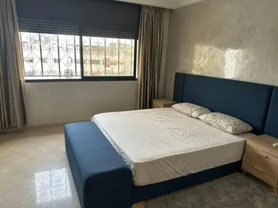 a bedroom with a blue bed and a window at apartment au coeur de Casablanca in Casablanca