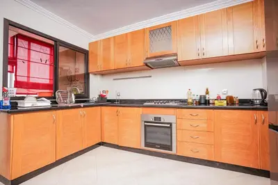 a large kitchen with wooden cabinets and appliances at apartment au coeur de Casablanca in Casablanca