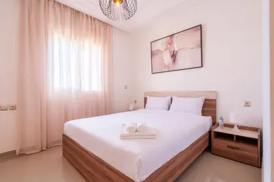 a bedroom with a large bed with two towels on it at Appartement Premium avec Piscine in Mohammedia