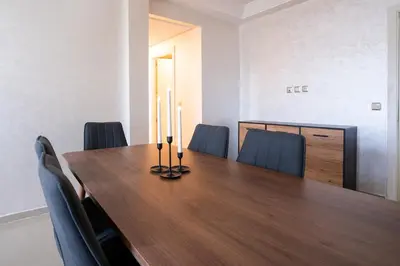 a conference room with a wooden table and chairs at Appartement Premium avec Piscine in Mohammedia