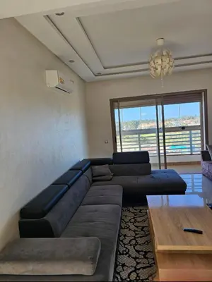 a living room with a large couch and a table at Bouznika rabat in Bouznika