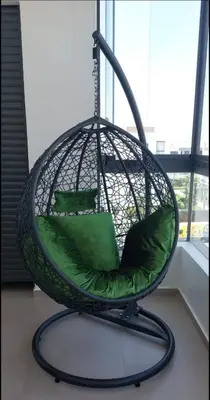a swing chair with green pillows in a room at Bouznika rabat in Bouznika