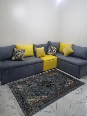 a blue couch with yellow pillows and a rug at Bayt El Fath in Casablanca