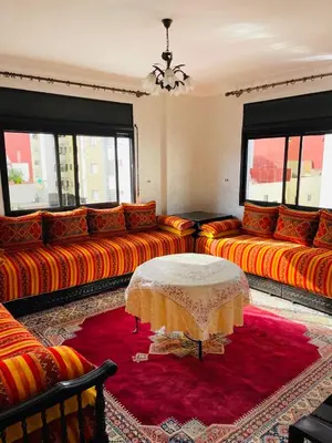 a living room with orange couches and a table at Perle de rabat in Rabat