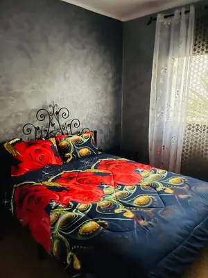 a bedroom with a bed with red and yellow flowers at Perle de rabat in Rabat
