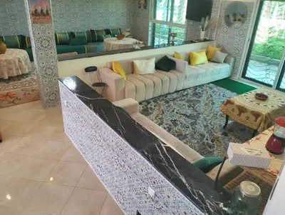 a living room with a couch and a table at RiadNA in Bouznika