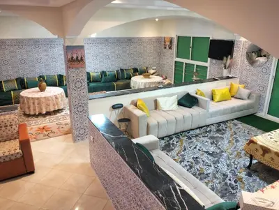 a living room with a couch and a table at RiadNA in Bouznika