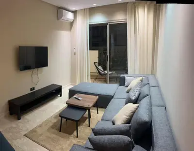 a living room with a blue couch and a tv at Badji in Casablanca