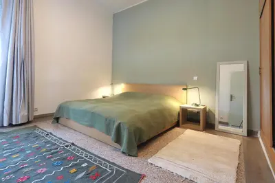 a bedroom with a large bed and a mirror at The 31 Grand Théâtre by IB Signature - Boho Chic 1BR Apt - with Wifi - Self check-in - 24 x7 Security - City View with terrace - Walk to Cafes! City Centre, Tram in Casablanca