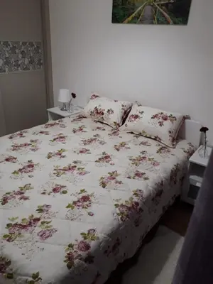a bed with a floral comforter on it in a bedroom at Appartement sur bd la corniche luxury house with garden close to beach in Casablanca