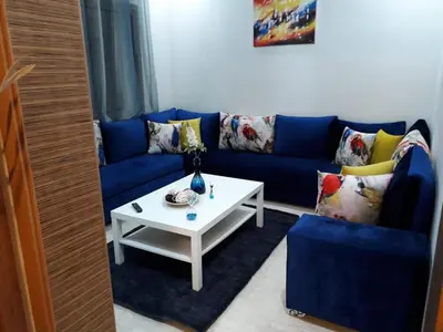 a living room with a blue couch and a white table at Appartement sur bd la corniche luxury house with garden close to beach in Casablanca