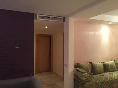 a room with a couch and a hallway with a door at Appartement de luxe à 3 min de l aéroport in Nouaseur