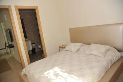 a bedroom with a bed with white sheets and a television at Appartement à gauthier in Casablanca