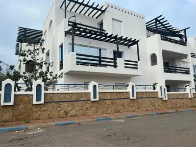 a white building with balconies on top of a wall at Évasion océanique skhirat in Skhirat