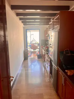 a kitchen with a long hallway with a refrigerator at Évasion océanique skhirat in Skhirat