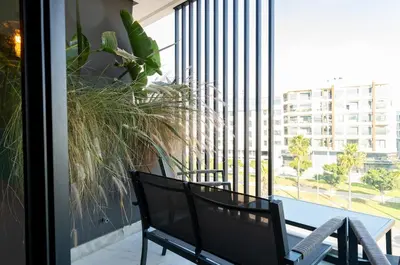 a balcony with a table and chairs and a large window at Luxury 1-Bedroom Apartment in Casablanca