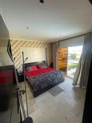 a bedroom with a bed with a red comforter at Maison fantastique à louer à Harhoura près de la plage Votre maison côtière de rêve in Temara