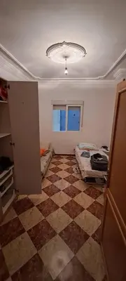 a room with a room with two beds and a window at Blue Wave Apartment in Temara