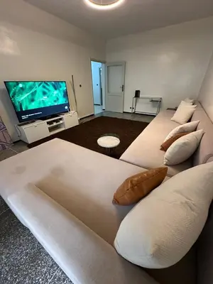 a large white bed with pillows and a flat screen tv at 3Bed-Room Appart Agdal City Center in Rabat