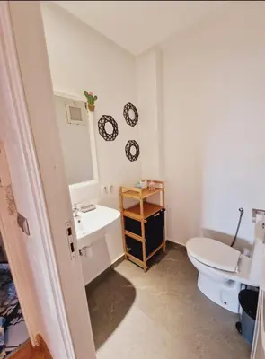 a bathroom with a white toilet and a sink at Elégant 3 pieces salon pour famille à 3 min de Hay riad Rabat in Temara