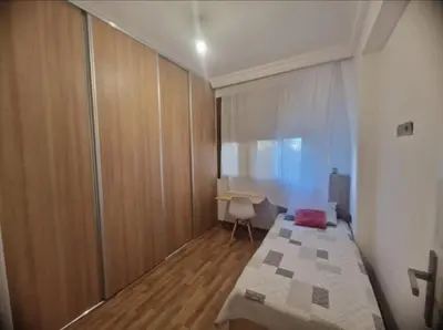 a small bedroom with a bed and a desk at Elégant 3 pieces salon pour famille à 3 min de Hay riad Rabat in Temara