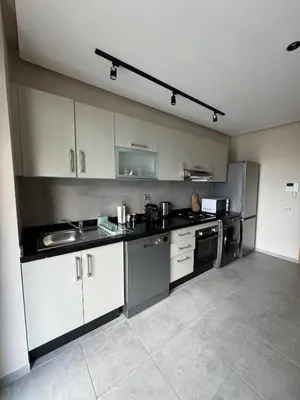 a large kitchen with white cabinets and appliances at Minimalist Escape - Between Rabat Agdal Station & Corniche in Rabat