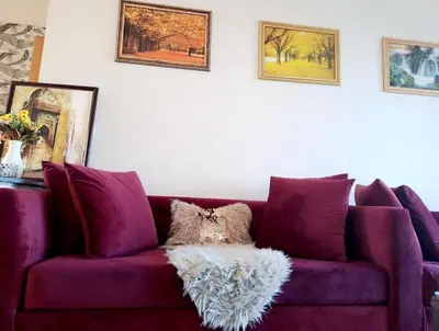 a purple couch in a living room with pictures on the wall at appartement à Mansouria avec piscine et accès a la mer Perla Andaloussia El Mansouria in Mansouria
