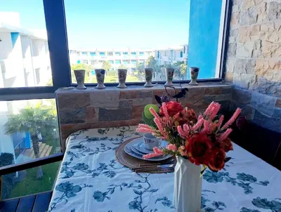 a table with a vase of flowers on a table at appartement à Mansouria avec piscine et accès a la mer Perla Andaloussia El Mansouria in Mansouria