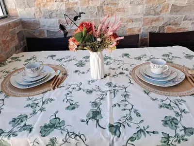a table with two cups and a vase with flowers at appartement à Mansouria avec piscine et accès a la mer Perla Andaloussia El Mansouria in Mansouria
