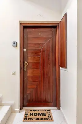 a wooden door with a welcome mat in front of it at Appartement Agdal, proche des stades in Rabat