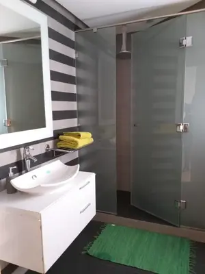 a bathroom with a sink and a shower with a mirror at Stunning one bedroom flat at Casablanca Marina 10th floor Sea View in Casablanca