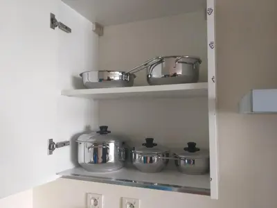 a row of pots and pans on a shelf in a kitchen at Stunning one bedroom flat at Casablanca Marina 10th floor Sea View in Casablanca