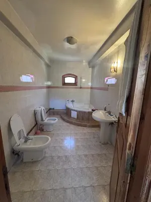 a bathroom with two sinks and a tub and two toilets at Villa élégante à Rabat,harhoura à 4 chambres in Rabat
