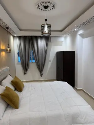 a bedroom with a large white bed with two pillows at Moderne berlin av terrasse in Rabat