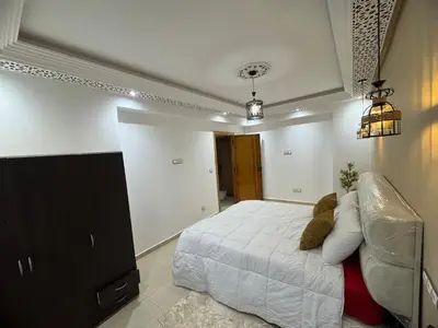 a bedroom with a bed and a couch at Moderne berlin av terrasse in Rabat