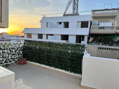 a white building with a green hedge on a balcony at Moderne berlin av terrasse in Rabat
