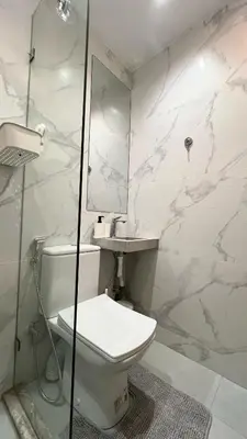 a white bathroom with a toilet and a mirror at Functional and Stylish Apartment in Agdal for Rabat Stay in Rabat