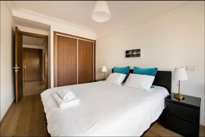 a bedroom with a large white bed with blue pillows at Tranquil in Casablanca