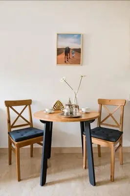 a wooden table with two chairs and a picture on the wall at Tranquil in Casablanca