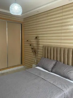a bedroom with a large bed and a potted plant at The Park Apartment in Mohammedia