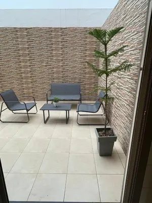 a patio with two chairs and a potted tree at The Park Apartment in Mohammedia