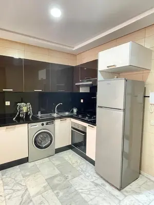 a kitchen with a white refrigerator and a dishwasher at The Park Apartment in Mohammedia