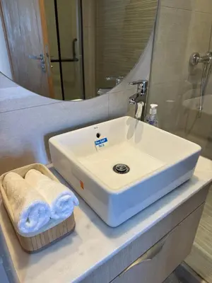 a bathroom with a white sink and a mirror at Évasion zen près de Casablanca - Vue imprenable sur le parc et la plage de l'Éco City Zenata in Aïn Harrouda