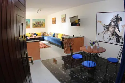 a living room with a blue couch and a table at Apartment Nahda Rabat in Rabat