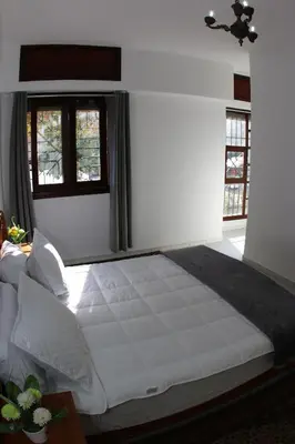 a large white bed in a room with windows at Apartment Nahda Rabat in Rabat