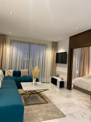 a living room with a blue couch and a bed at Quartier l oasis prêt de la gare in Casablanca